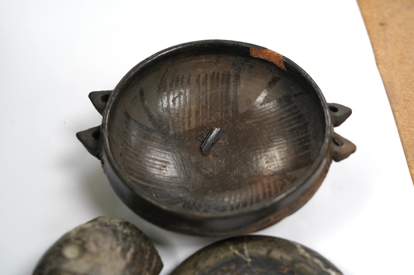 An African Dogon tribe carved stone bracelet, 10cm diameter, an Ethiopian black glazed terracotta bowl, 11cm diameter, Gurage people, and a carved black stone head of a monkey, 5.5cm, possibly North American. Condition -